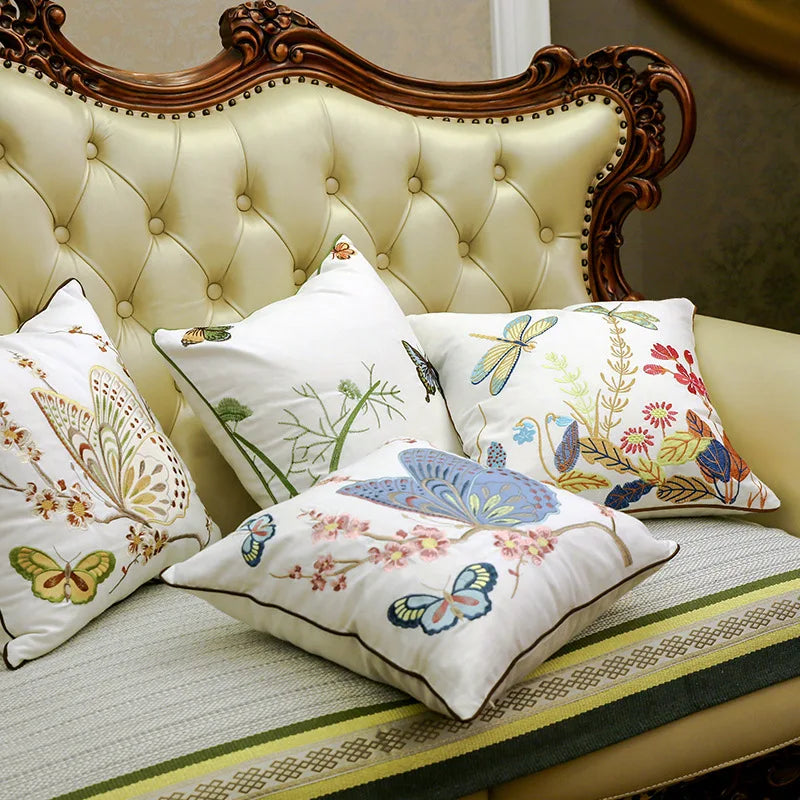 Une élégante tête de lit ornée de motifs floraux et de papillons colorés, accompagnée de coussins décoratifs assortis, crée une ambiance chaleureuse et romantique dans cette chambre.