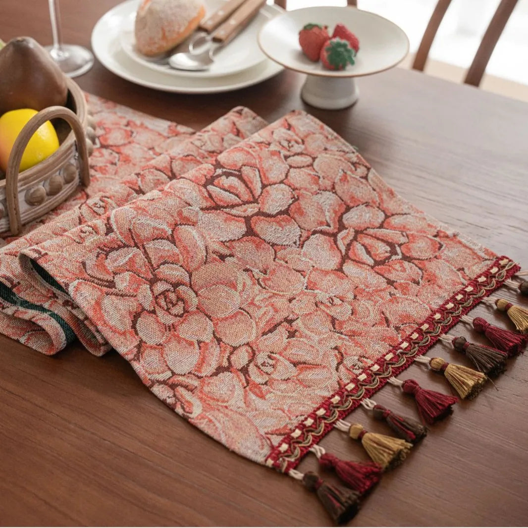 Ce linge de table rouge et beige à motifs floraux apporte une touche décorative chaleureuse à la table.