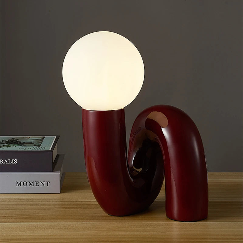 Lampe de chevet rouge posée sur une table de nuit