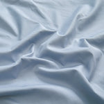 Une texture de tissu gris clair, avec des plis et des ondulations délicates, créant une atmosphère apaisante et relaxante.