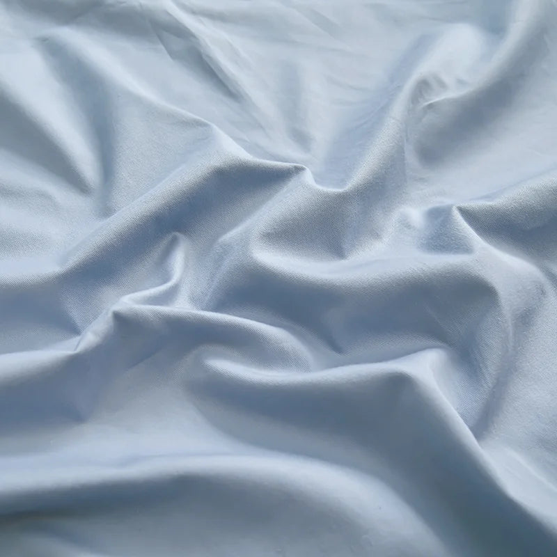 Une texture de tissu gris clair, avec des plis et des ondulations délicates, créant une atmosphère apaisante et relaxante.