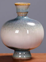 Vase décoratif en céramique avec un design élégant et des tons dégradés gris et orange.