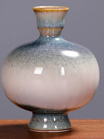 Vase décoratif en céramique avec un design élégant et des tons dégradés gris et orange.