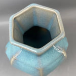 Vase hexagonal en céramique aux couleurs pastel avec des touches argentées.