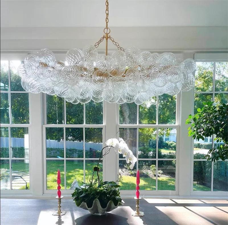 suspension lumineuse moderne verre transparent chaîne dorée led acier poli contemporain lumière chaude chambre