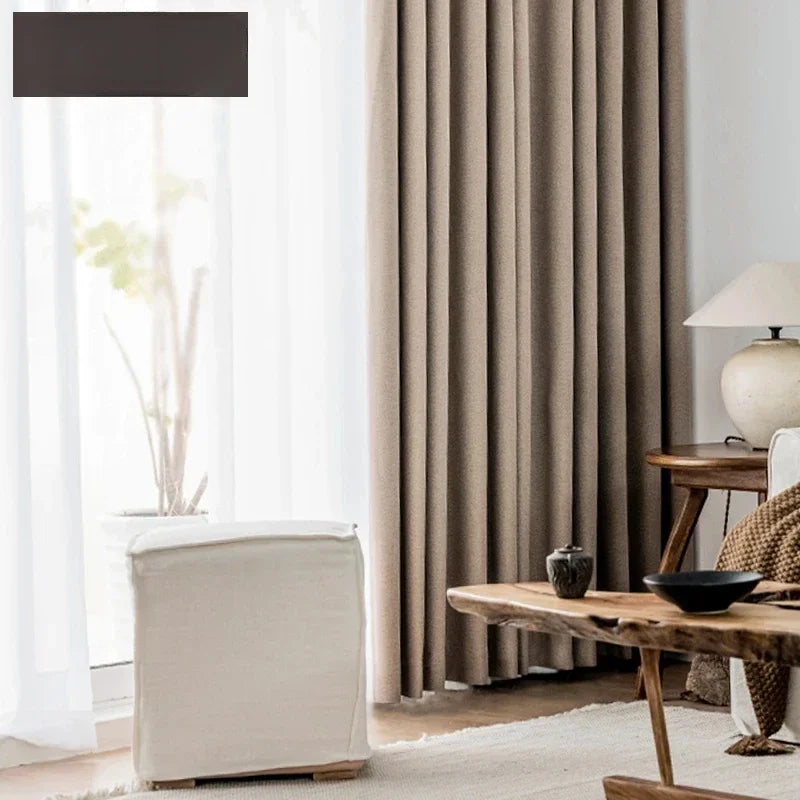 Des rideaux beige pour habiller les fenêtres d'un salon contemporain, rehaussés d'une touche de textile gris, mettant en valeur le mélange artistique du linge de maison dans la décoration d'intérieur.
