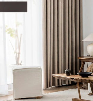 Des rideaux beige pour habiller les fenêtres d'un salon contemporain, rehaussés d'une touche de textile gris, mettant en valeur le mélange artistique du linge de maison dans la décoration d'intérieur.
