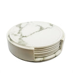 Des sous-verres ronds en marbre blanc avec motifs gris constituent un ensemble élégant et durable pour protéger les surfaces.