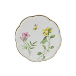 Une assiette décorative en porcelaine blanche ornée de fleurs et de feuillage colorés.