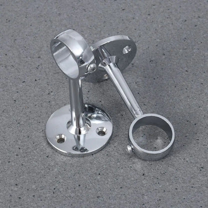 Deux supports muraux chromés croisés sur un fond gris, adaptés aux tringles extensibles.