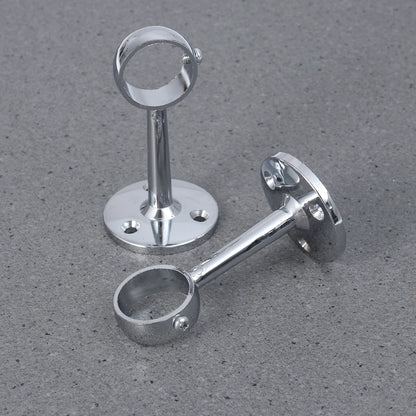 Deux supports chromés solides pour tringle à rideaux, disposés sur un sol gris texturé.