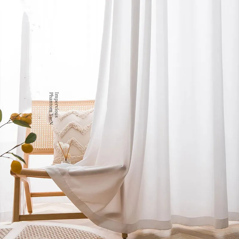 Voilage blanc à galon fronceur tombant avec élégance sur un fauteuil en bois naturel dans un décor lumineux.