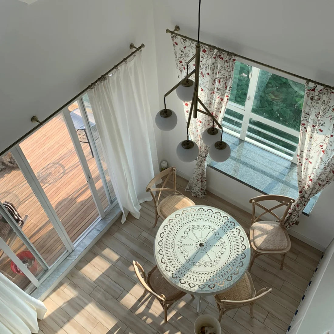 Tringles à rideaux en métal vieilli installées sur baies vitrées et fenêtres dans une pièce baignée de lumière