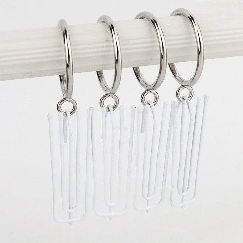 Anneaux de rideau argentés modernes accrochés à une tringle blanche, avec crochets blancs, idéals pour une installation facile de rideaux dans la salle de bain ou la cuisine. Design élégant et fonctionnel.