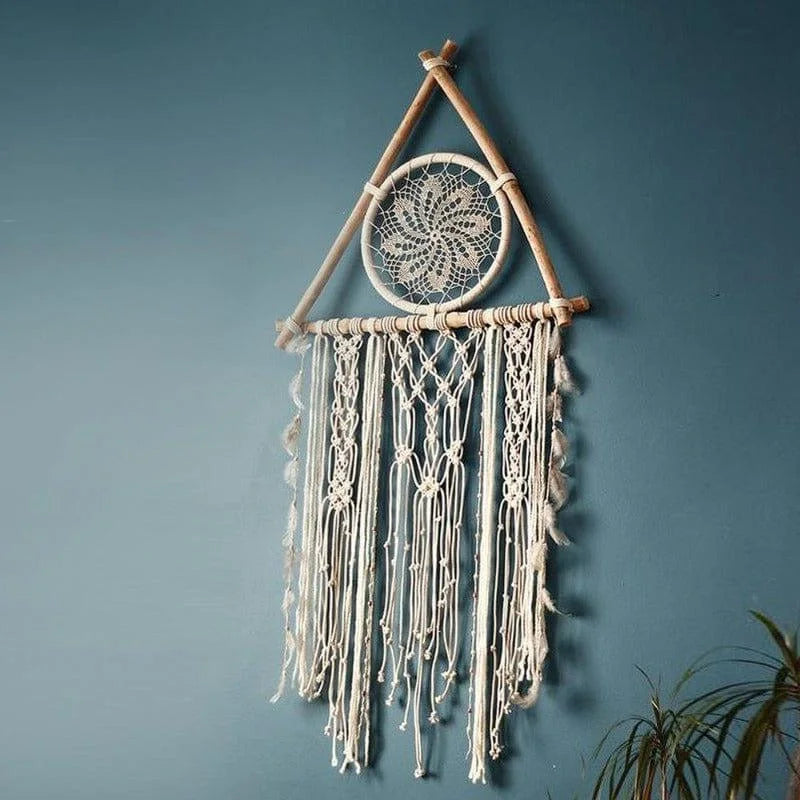 Décoration murale bohème avec motif tribal suspendue sur un mur bleu, idéale pour ajouter une touche artistique et apaisante à votre intérieur. Parfait pour les amateurs de design ethnique et les espaces de vie modernes. Transformez votre pièce avec cet attrape-rêves élégant et détaillé.