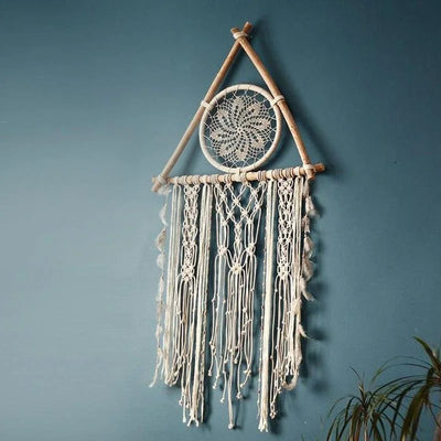 Décoration murale bohème avec motif tribal suspendue sur un mur bleu, idéale pour ajouter une touche artistique et apaisante à votre intérieur. Parfait pour les amateurs de design ethnique et les espaces de vie modernes. Transformez votre pièce avec cet attrape-rêves élégant et détaillé.