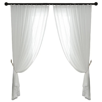 Voilage blanc accroché avec embrasses décoratives sur une tringle noire.