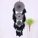 Attrape-rêves noir suspendu avec plumes élégantes, parfait pour décorer une chambre ou un salon, apportant une touche bohème et apaisante à votre intérieur. Objet décoratif idéal pour filtrer les rêves et créer une ambiance relaxante.