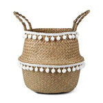 Panier de rangement décoratif avec pompons blancs, idéal pour l'organisation et la décoration intérieure. Design bohème et pratique, parfait pour le salon, la chambre ou la salle de bain. Poignées robustes pour un transport facile. Accessoire tendance pour un intérieur chaleureux et stylé.