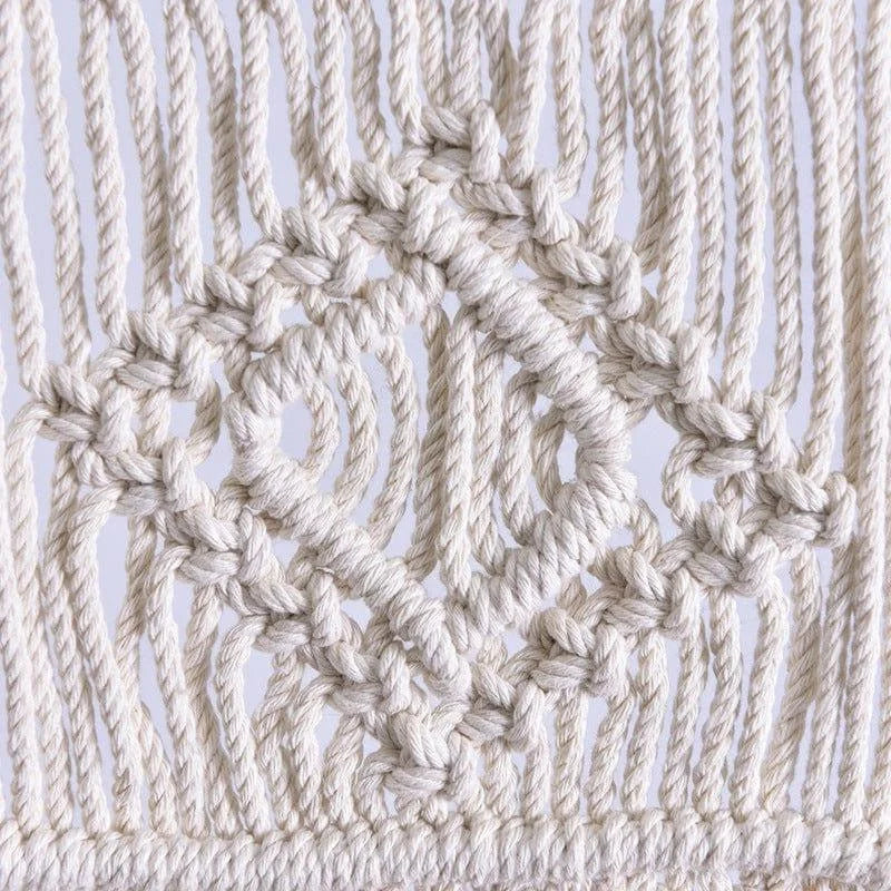 Détail d'une création en macramé avec un motif géométrique, idéal pour ajouter une touche d'artisanat à votre décoration intérieure. Design élégant mettant en valeur des noeuds complexes pour un style bohème.
