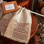 Rideau décoratif vintage avec bordures en dentelle, idéal pour ajouter une touche élégante à votre intérieur, suspendu dans un cadre rustique avec une petite photo encadrée et des fleurs en arrière-plan. Parfait pour les cuisines ou salons au style rétro-chic.