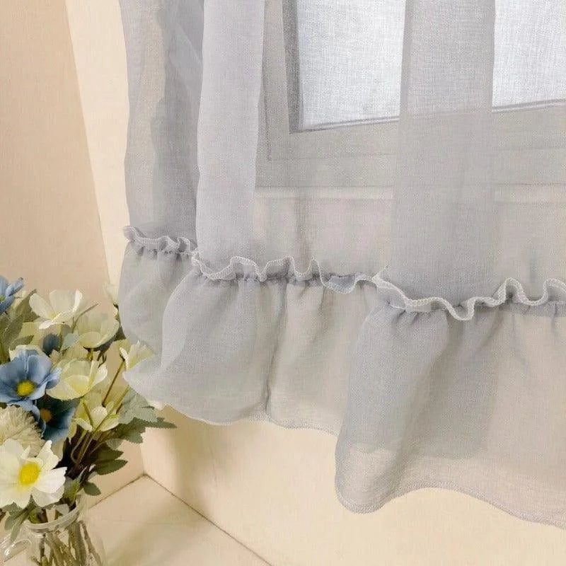 Voilage élégant pour fenêtre avec volants en bas en blanc vaporeux, idéal pour ajouter une touche romantique à votre intérieur. Transformez votre espace grâce à ce rideau raffiné, parfait pour admissions de lumière douce dans votre salon ou chambre. Décoration florale incluse pour une présentation harmonieuse de votre maison.