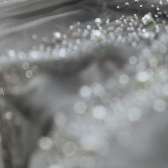Effet scintillant d'un rideau transparent gris avec décor de perles lumineuses.