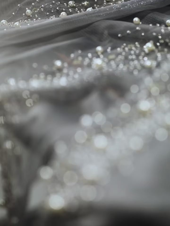 Effet scintillant d'un rideau transparent gris avec décor de perles lumineuses.