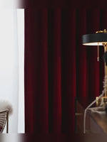 Vidéo montrant un rideau occultant bordeaux en velours dans un salon chic avec lampe dorée, ambiance feutrée et tamisée.