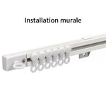 Rail de rideau blanc monté au mur avec crochets glissants, parfait pour suspendre des rideaux avec élégance et stabilité.