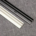 Rails de support noir et blanc sur fond textile gris, idéaux pour installations murales modernes et design élégant. Solution pratique pour fixation sécurisée et discrète. Accessoires polyvalents pour divers aménagements intérieurs.