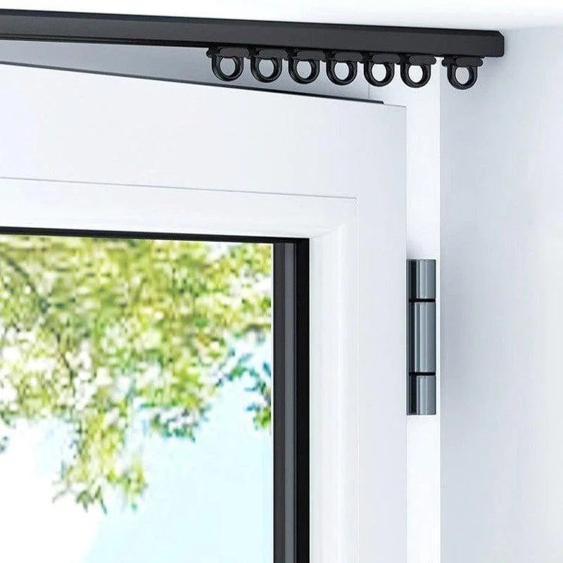 Rail de rideau noir, fixé au-dessus d'une porte-fenêtre moderne. Système de suspension avec anneaux, idéal pour une installation élégante et discrète. Permet un glissement fluide des rideaux, parfait pour optimiser l'espace intérieur tout en ajoutant une touche contemporaine à votre décoration.