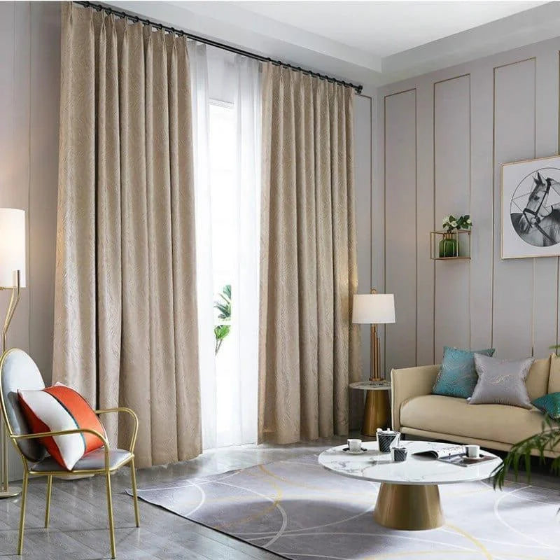 Rideaux élégants couleur beige ajoutant une touche de sophistication à un salon moderne, éclairé naturellement par une grande fenêtre, avec une décoration intérieure contemporaine incluant un canapé confortable, un tapis style géométrique et des accessoires décoratifs.