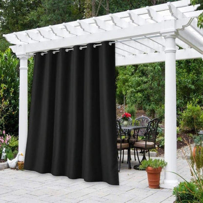 Voilage d'extérieur noir élégant suspendu sous une pergola blanche dans un jardin verdoyant, offrant une ambiance intime et raffinée pour se détendre en plein air. Ajoutez une touche de sophistication à votre espace extérieur avec ces rideaux qui vous protègent du soleil tout en créant une atmosphère chaleureuse. Parfait pour les réunions en famille ou entre amis, avec en arrière-plan un coin salon de jardin accueillant et fleuri.