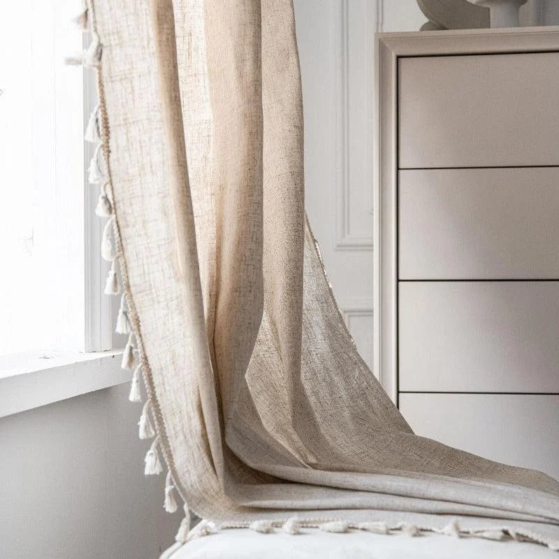 Voilage beige élégant avec pompons, idéal pour une décoration intérieure apaisante. Ce rideau raffiné habille vos fenêtres en laissant passer une lumière douce, créant ainsi une ambiance chaleureuse et accueillante. Parfait pour le salon ou la chambre, il s'intègre harmonieusement dans un style moderne ou classique. Accessoire essentiel pour sublimer votre espace de vie.