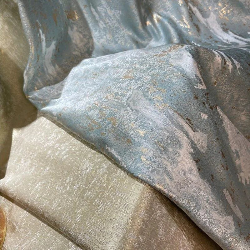 Tissu décoratif haut de gamme, présentant un motif abstrait avec des nuances bleues et dorées, idéal pour la confection de rideaux élégants ou pour un ameublement luxueux. Ce textile confère une touche sophistiquée à tout intérieur grâce à son design raffiné et ses couleurs harmonieuses.