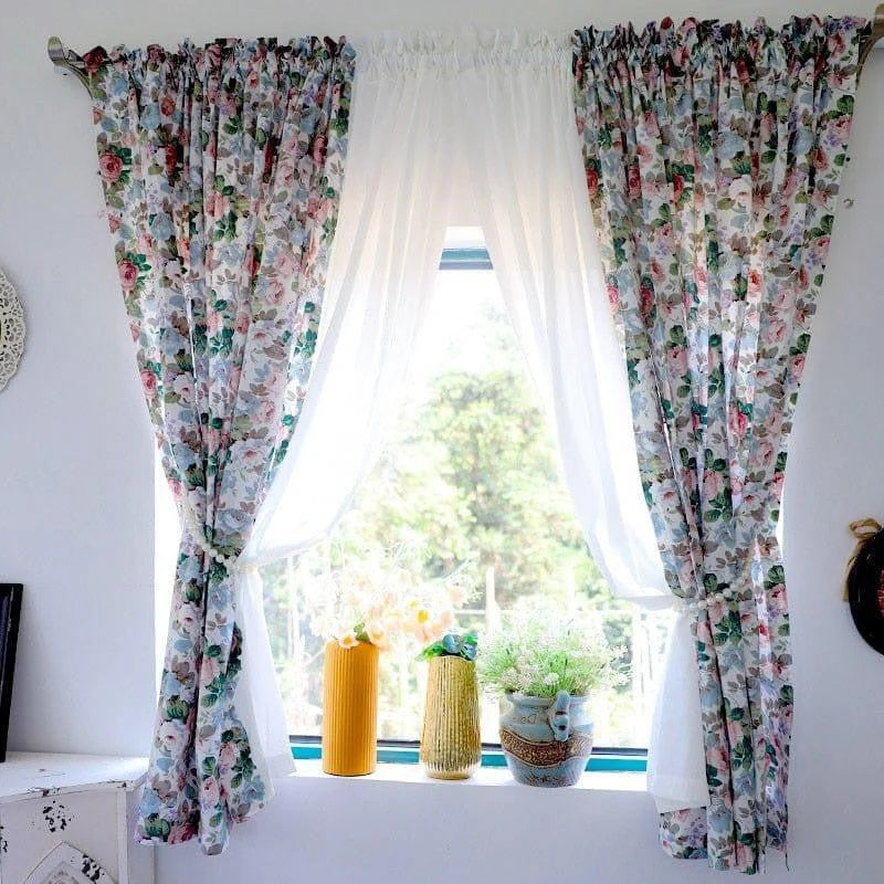 Rideaux fleuris élégants décorant une fenêtre lumineuse. Idéal pour apporter une touche printanière à votre intérieur, ces rideaux avec motifs floraux s'harmonisent parfaitement avec un décor moderne ou classique. Transformez l'ambiance de votre pièce avec style et subtilité.