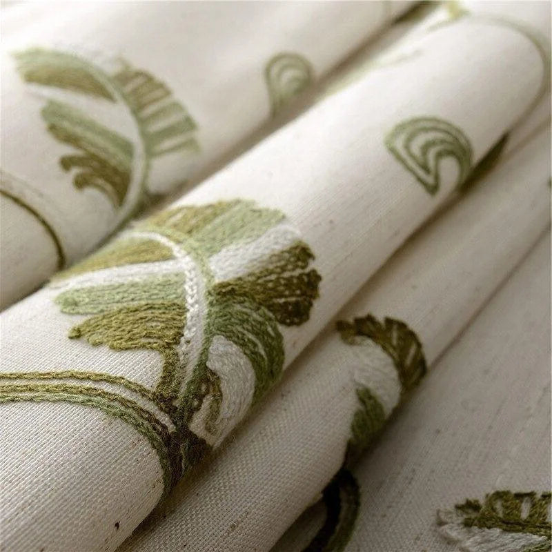 Tissu décoratif beige aux motifs brodés verts, idéal pour la confection de rideaux ou d'ameublement intérieur. Design élégant inspiré de la nature, parfait pour ajouter une touche de fraîcheur à votre décoration intérieure. Finition soignée et motifs végétaux subtils pour un style moderne et raffiné.