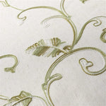 Image d'un tissu raffiné avec des motifs brodés en forme de feuilles et de volutes dans des teintes vertes et blanches, idéal pour la décoration intérieure élégante. Design floral délicat et détaillé, parfait pour ajouter une touche naturelle et sophistiquée à votre espace de vie.