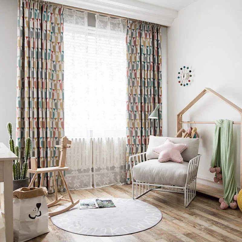 Chambre d'enfant lumineuse et moderne décorée avec des rideaux à motifs géométriques colorés. Fauteuil confortable agrémenté d'un coussin en forme d'étoile rose, tapis rond mignon avec des lettres, ambiance accueillante et ludique idéale pour les petits. Éléments de décoration amusants et pratiques pour une chambre d'enfant harmonieuse.