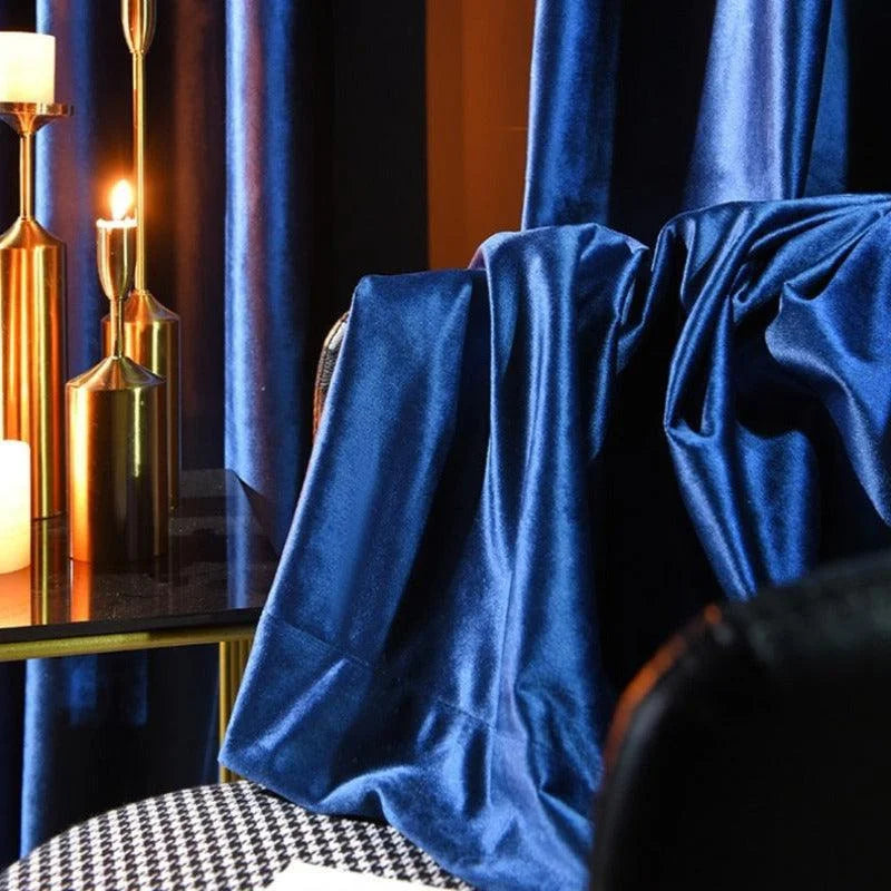 Rideaux élégants en bleu nuit, idéals pour ajouter une touche de sophistication à votre intérieur. Parfaits pour le salon ou la chambre, ces rideaux créent une ambiance chaleureuse et accueillante. Accessoirisés par des éléments dorés et des bougies, ils apportent une touche luxueuse et moderne à votre espace.