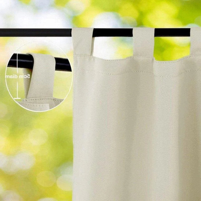 Rideau beige avec passants de fixation visibles suspendu à une tringle noire, idéal pour ajouter une touche élégante à la décoration d'intérieur. Adapté à diverses ambiances, il permet un accrochage facile et rapide grâce à ses grandes boucles pratiques pour toutes vos fenêtres.