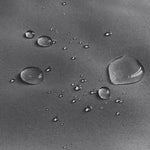 Gouttelettes d'eau sur une surface imperméable noire, démontrant l'efficacité de la protection contre l'humidité. Découvrez une performance exceptionnelle contre l'eau pour une utilisation optimale en extérieur. Idéal pour garder vos affaires au sec, peu importe les conditions météorologiques.