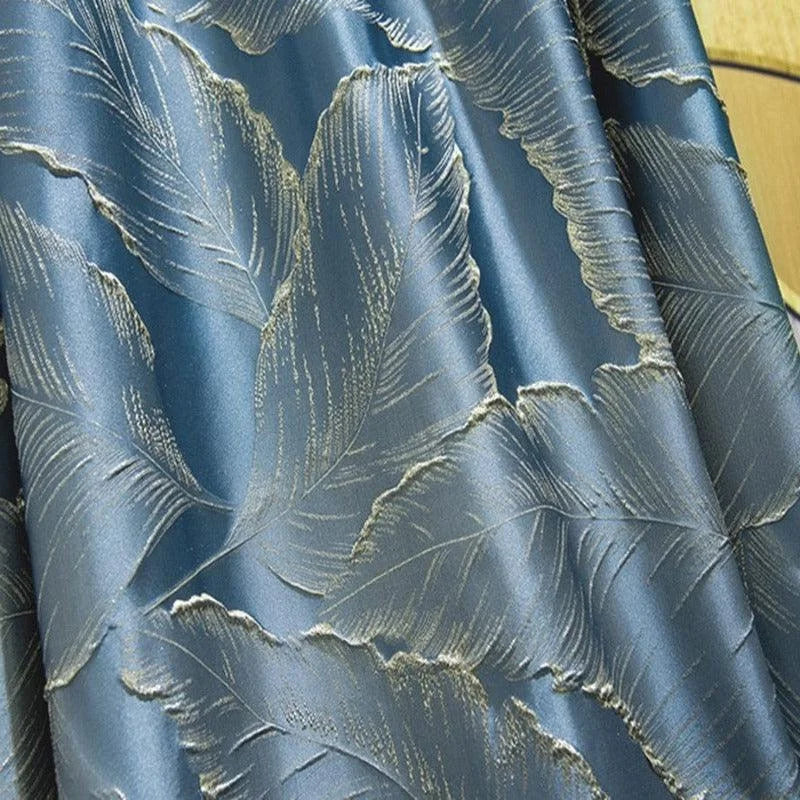 Rideau bleu élégant avec motif de feuilles dorées, idéal pour ajouter une touche sophistiquée à votre décoration intérieure. Cette pièce offre une ambiance chic et moderne à votre salon ou chambre à coucher, avec des motifs subtils qui captent la lumière et créent une atmosphère apaisante. Parfait pour ceux qui recherchent un style raffiné et contemporain.