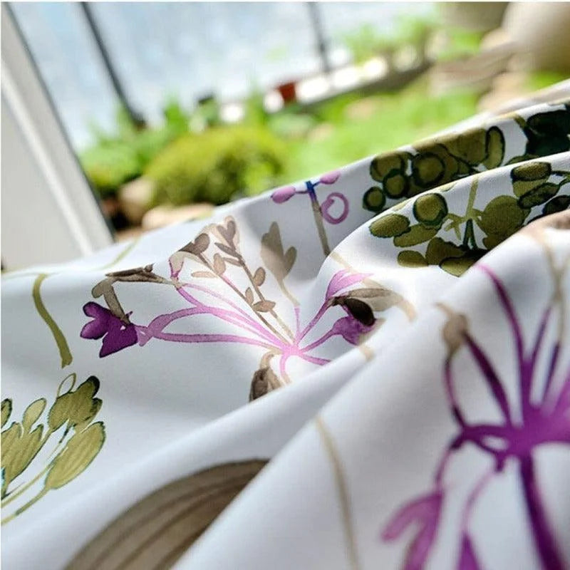 Image d'un tissu élégant avec un motif floral raffiné aux tons verts et violets, idéal pour des projets de décoration intérieure modernes et naturels. Parfait pour apporter une touche de fraîcheur et d'élégance à votre espace de vie, adapté aux rideaux, nappes, ou housses de coussin. Ce design floral contemporain évoque une ambiance paisible et accueillante, parfaite pour un intérieur harmonieux.