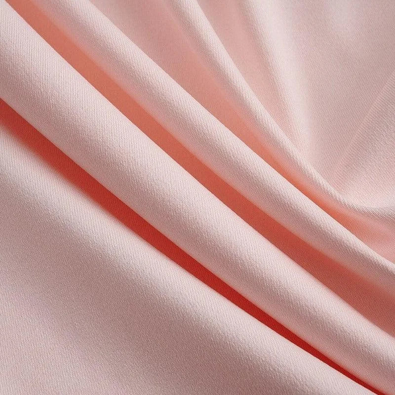 Image d'un tissu rose doux, idéal pour la confection de vêtements ou d'accessoires décoratifs. Ce textile présente une texture lisse et élégante, parfaitement adapté à une utilisation dans des projets de couture créatifs ou pour embellir votre intérieur.