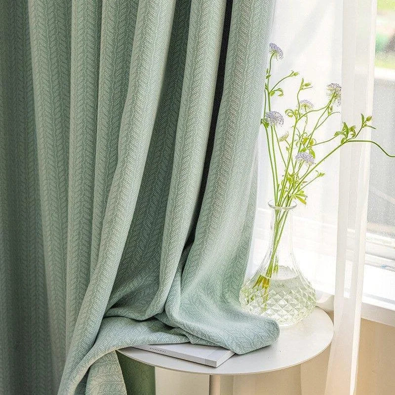 Rideau élégamment drapé de couleur vert doux, ajoutant une touche de sophistication et de fraîcheur à votre intérieur. Idéal pour améliorer la luminosité de votre salon ou chambre tout en préservant l'intimité. Accessoirisé d'un vase à motif transparent avec des fleurs délicates, ce décor inspire une ambiance apaisante et naturelle.