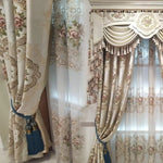 Rideaux élégants à motifs floraux avec embrasses décoratives bleues, éléments festonnés et détails en franges. Idéal pour embellir le salon ou la chambre, ce design raffiné apporte une touche de sophistication à votre intérieur.