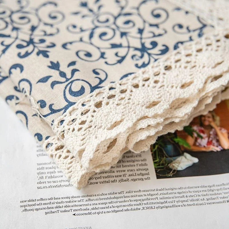 Nappe élégante avec motifs décoratifs bleus et bordure en dentelle, idéale pour rehausser la décoration de votre table. Parfaite pour ajouter une touche de sophistication et de charme vintage à vos repas et réceptions.