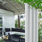 Rideau blanc élégant utilisé pour séparer un espace extérieur sous une pergola, apportant une touche moderne et sophistiquée à votre terrasse. Idéal pour créer une ambiance accueillante et privée, ce rideau est parfait pour les moments de détente en plein air, entouré de verdure tropicale.